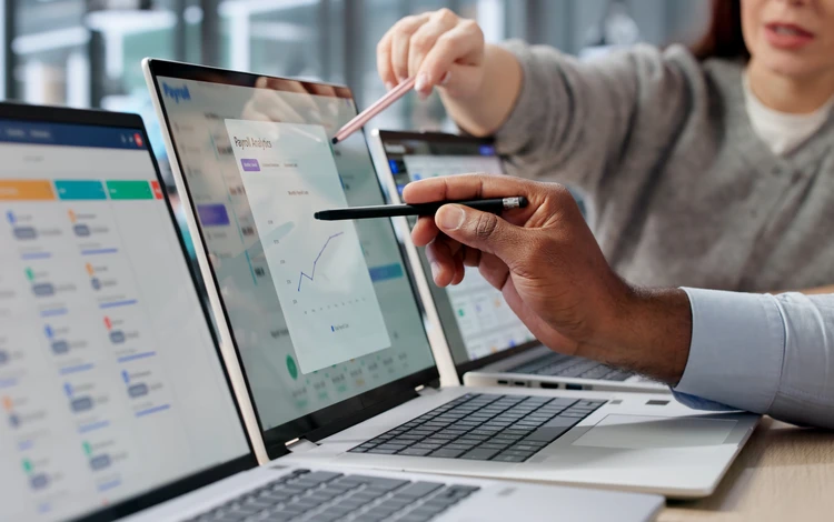 Personne en costume travaillant sur tablette tactile dans environnement de bureau moderne