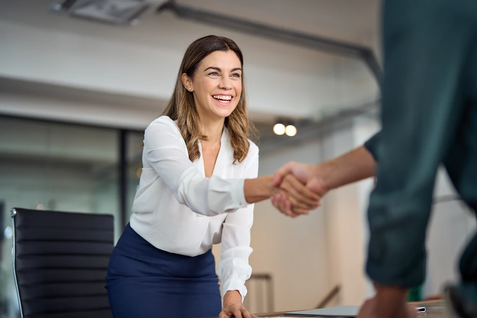Deux professionnels en réunion de travail autour d'une table blanche moderne